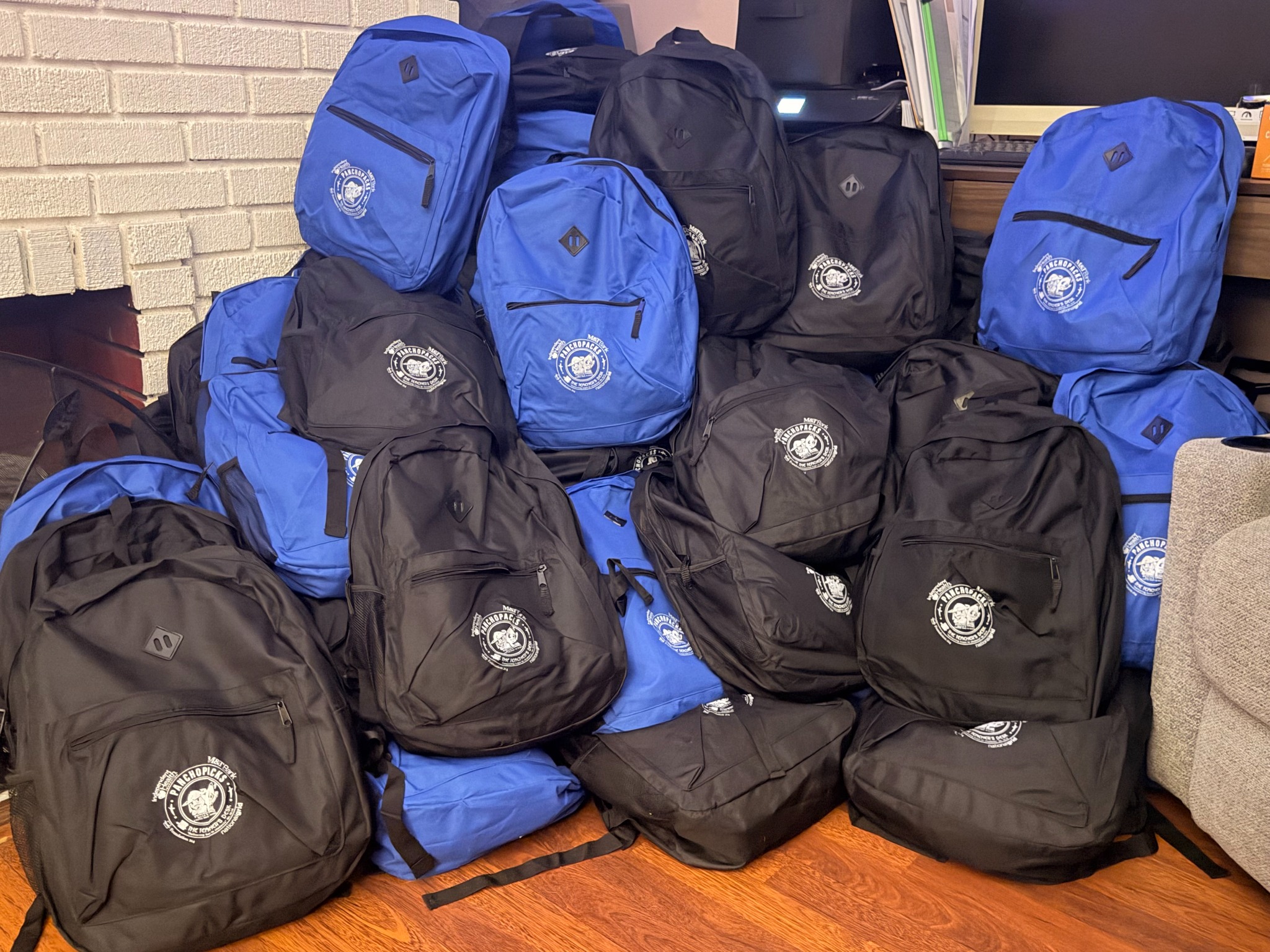 A large group of backpacks prepared for community distribution