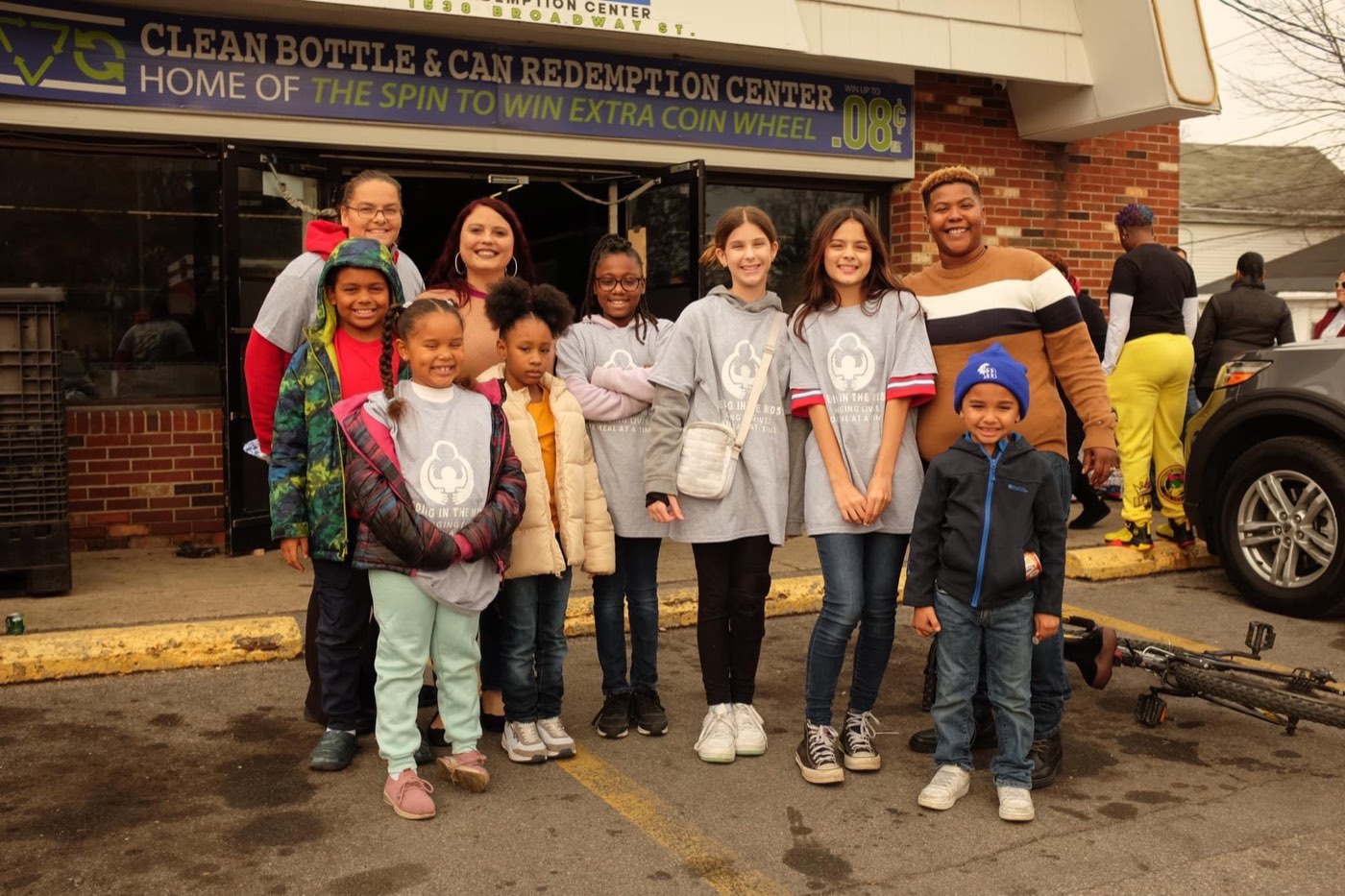 Volunteers and young people gathered outside a bottle and can redemption center