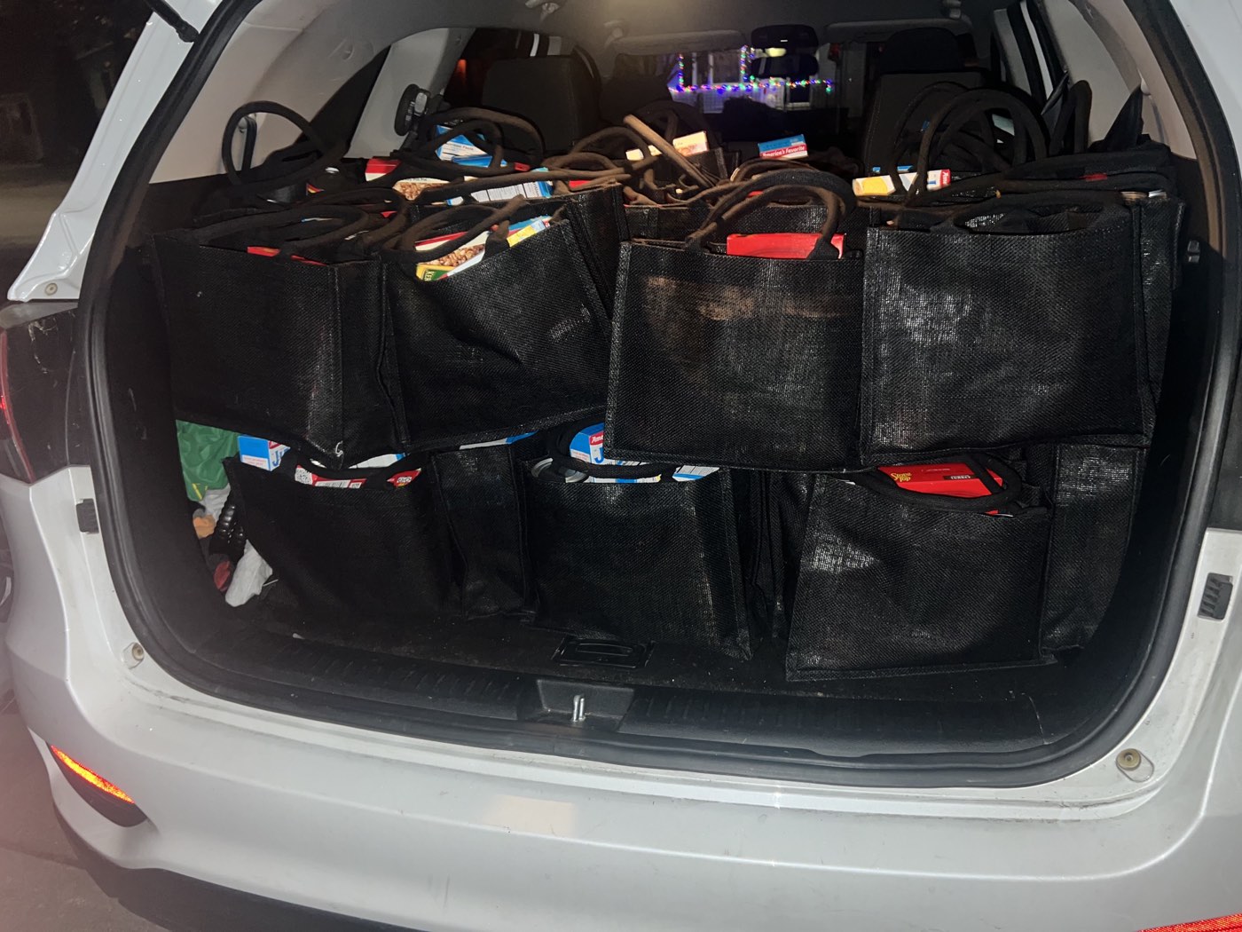 A vehicle loaded with dozens of filled grocery bags ready for delivery