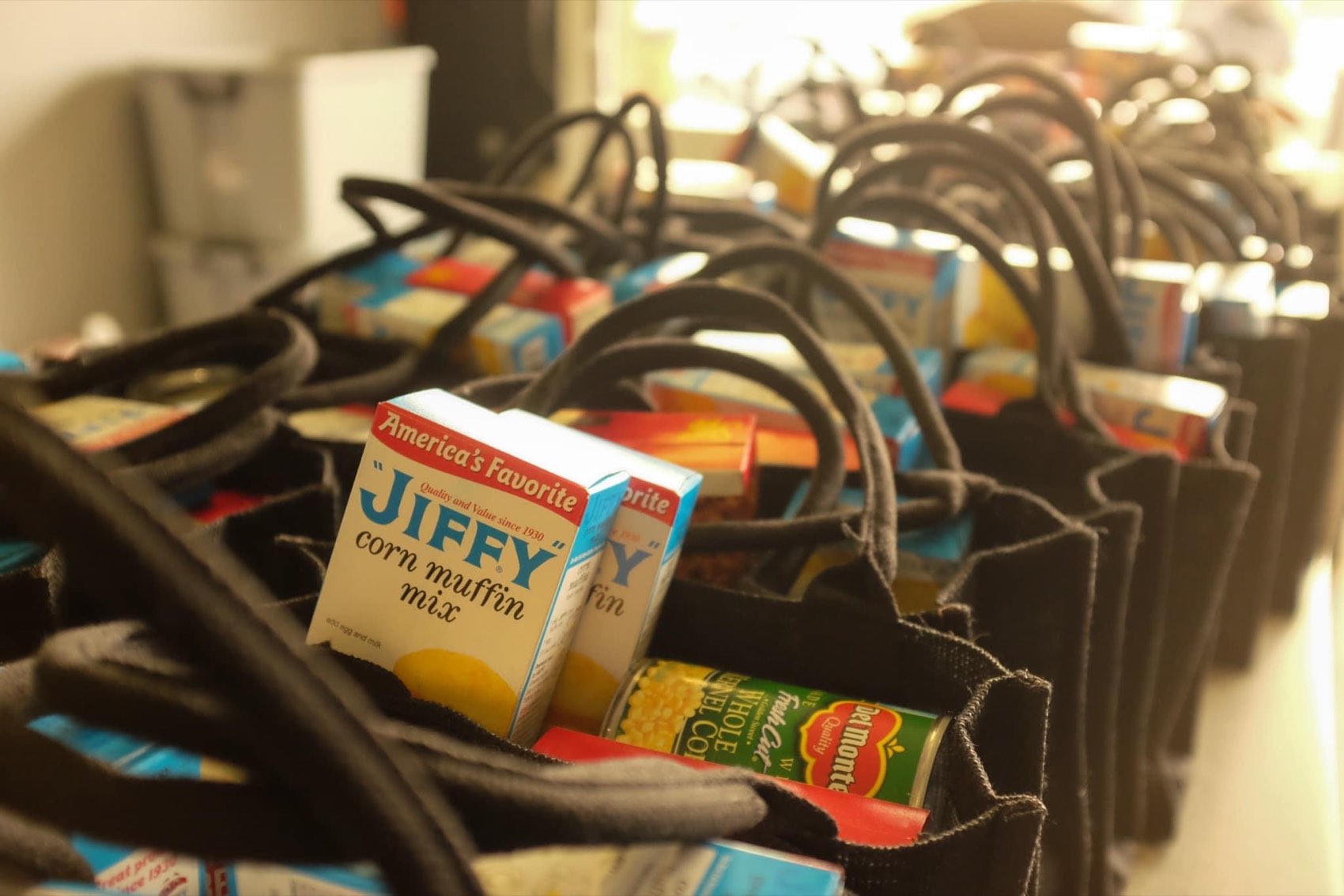 Rows of packed grocery bags filled with food, ready for distribution